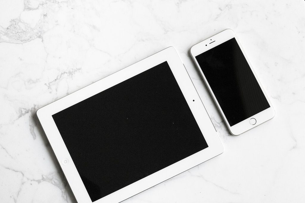 Beyaz masa üzerinde tablet ve telefon