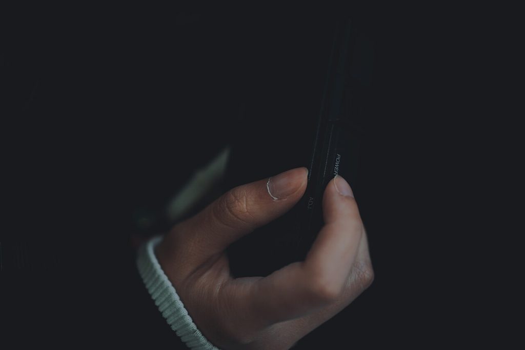 Loş ortamda akıllı telefon kullanan el